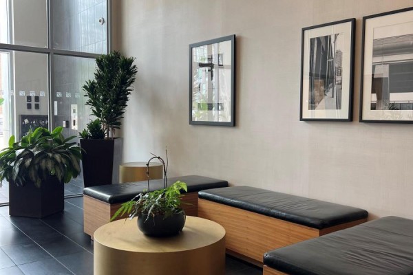 Waiting area with black benches, wooden accents, and potted plants. - 103 - 510 King Street E, Toronto