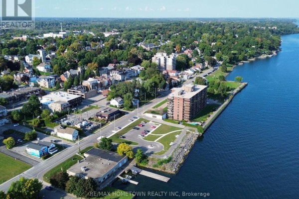 Aerial view of apartment building on waterfront with surrounding town and water visible. - 103 - 55 Water Street E, Brockville