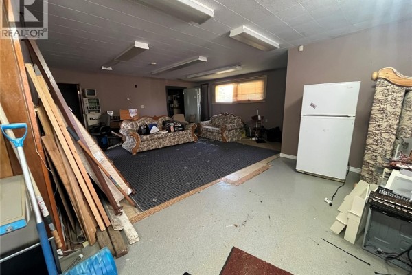 Spacious interior room with gray carpet, white appliances, and wood trim. - 103 1st Avenue W, Paynton