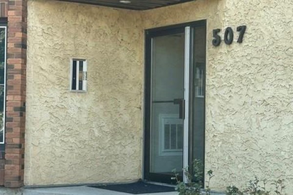 Apartment building exterior entrance with number '507' and stucco finish. - 103 507 Tait Crescent, Saskatoon