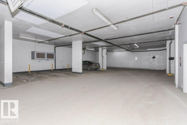 Underground parking garage with a single car parked and concrete floor. - #103 9819 104 St Nw, Edmonton