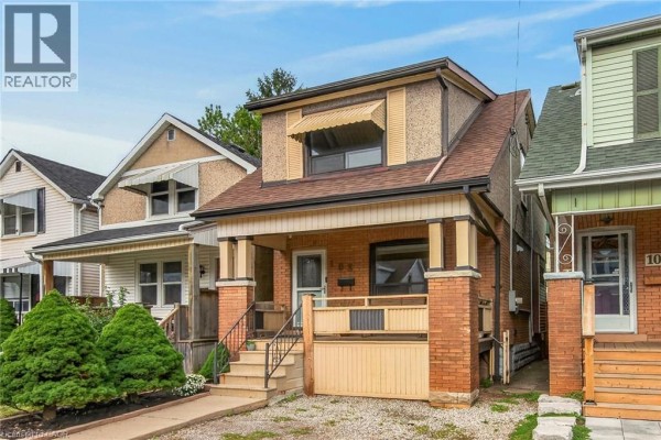 View of the house front from the left side. The property has a brick exterior with a gabled dormer window. - 103 Belmont Avenue, Hamilton