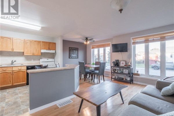 Open concept living and dining area with a kitchen island and dining table. - 103 Cedar Green Drive, Garson
