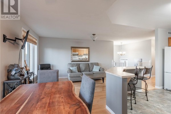 Dining area with a live edge table and chairs, adjacent to the kitchen and living room. - 103 Cedar Green Drive, Garson