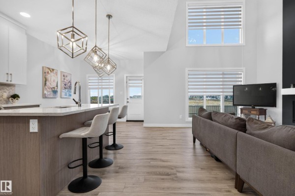 Open concept living area showing the kitchen island and view towards the living room. - 103 Edgefield Wy, St  Albert