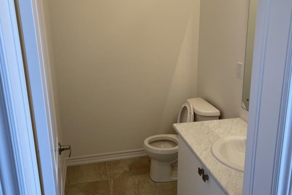 A powder room with a toilet, vanity, sink, and tiled floor. - 103 Nottingham Road, Barrie