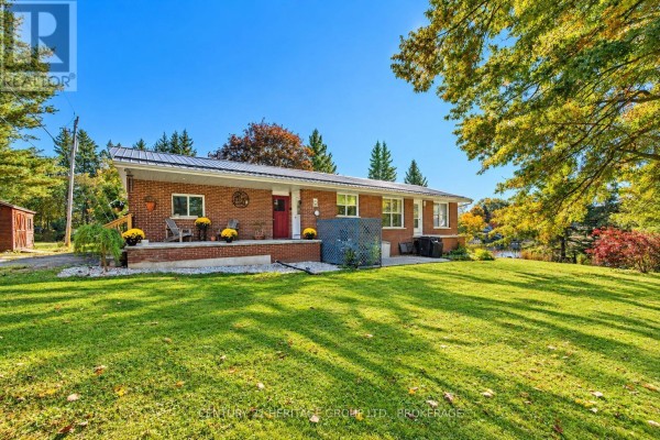 Brick house with a large green lawn, mature trees, and a bright blue sky. - 103 Rocklind Close Lane, Front Of Leeds & Seeleys Bay
