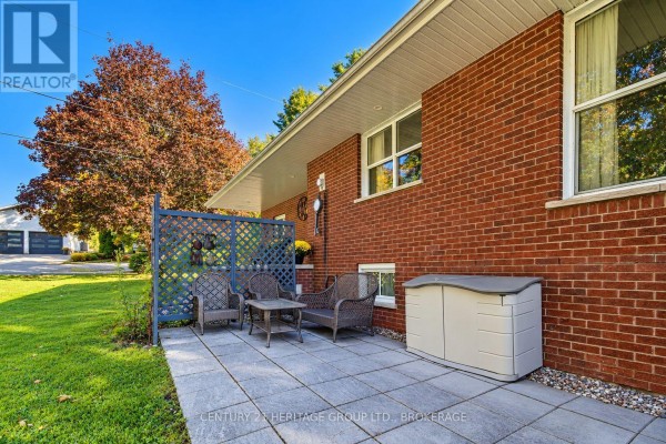 Stone patio with wicker furniture and storage box beside a red brick house. - 103 Rocklind Close Lane, Front Of Leeds & Seeleys Bay