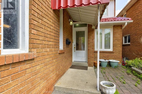 Entrance to the house with a glass-paneled door, red awning, and brick exterior. - 103 Whitchurch Mews, Mississauga