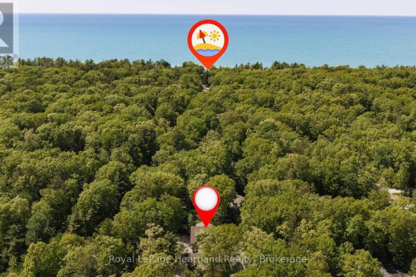 Aerial view of a wooded area with two location markers and the blue lake in the distance. - 10308 Beach O' Pines Road, Lambton Shores