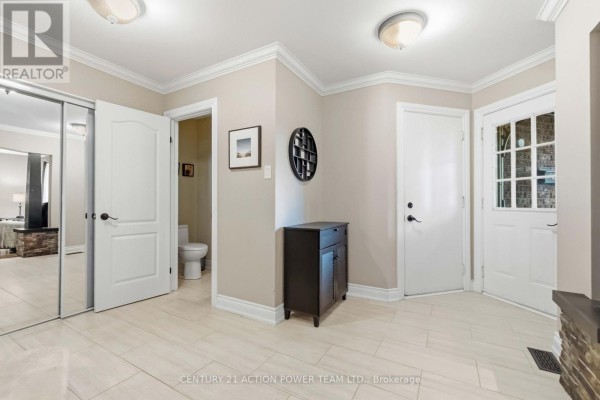 Hallway with beige walls, cream floor tiles, and closet doors. - 1032 Sheenboro Crescent, Ottawa