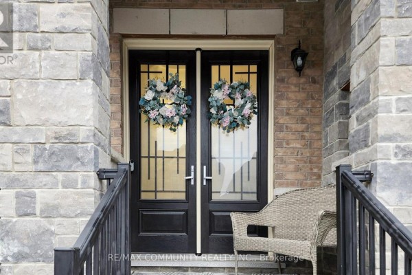 Close-up of the black double front doors with glass panels and floral wreaths. - 1034 Skyridge Boulevard, Pickering