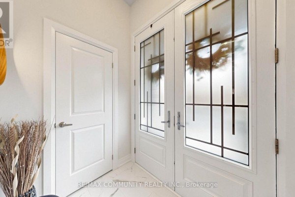 Interior foyer with white doors, decorative dried grass, and a large mirror. - 1034 Skyridge Boulevard, Pickering