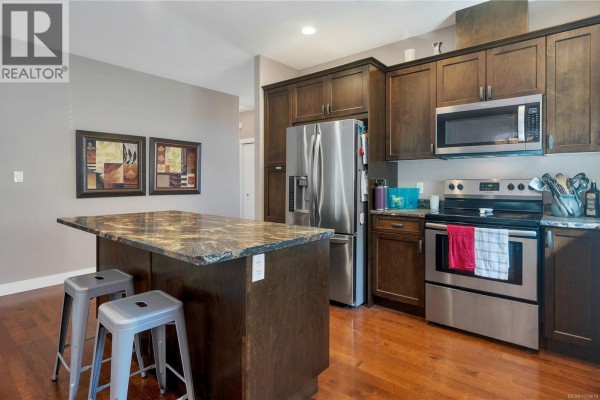 Another angle of the kitchen with a focus on the island and modern appliances. - 1037 Cordero Cres, Campbell River