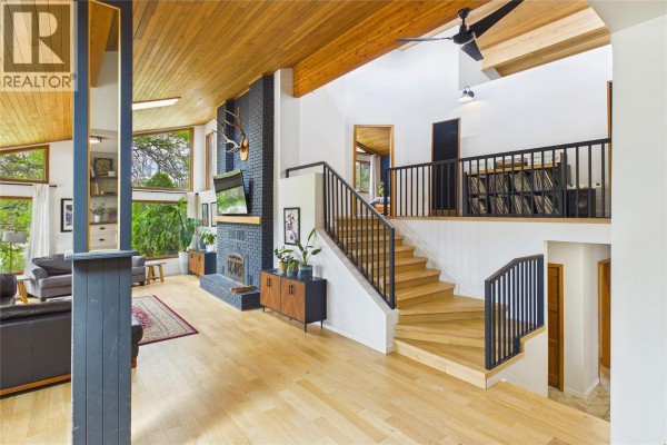 Interior view showing a living room, stairs leading to upper level, and wood-paneled ceiling. - 10371 Okanagan Centre Road E, Lake Country