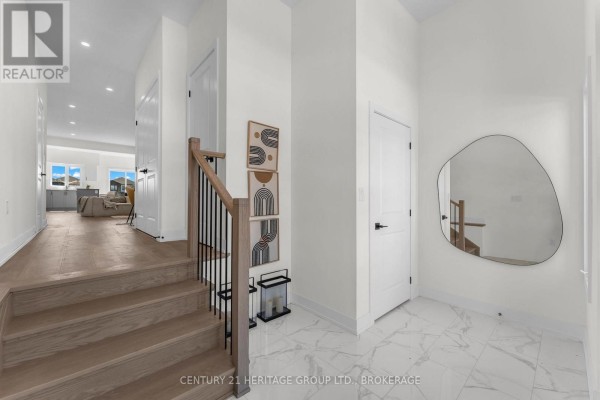 Foyer with hardwood stairs, modern railing, and geometric wall art. - 104(lot 55) Creighton Drive, Loyalist