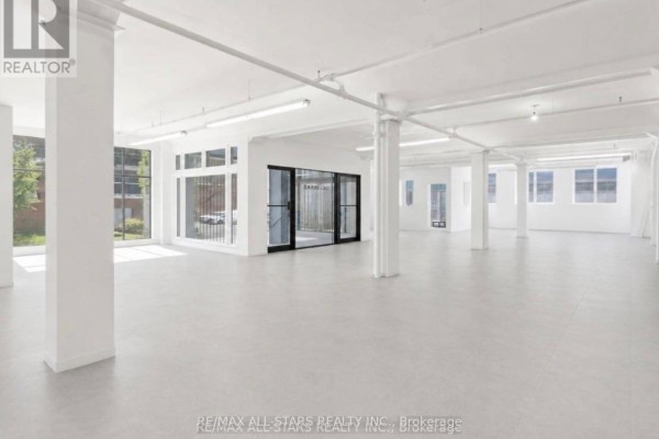 Commercial space with plywood flooring, large windows, and white walls. - 104 - 14 Mccaul Street, Toronto