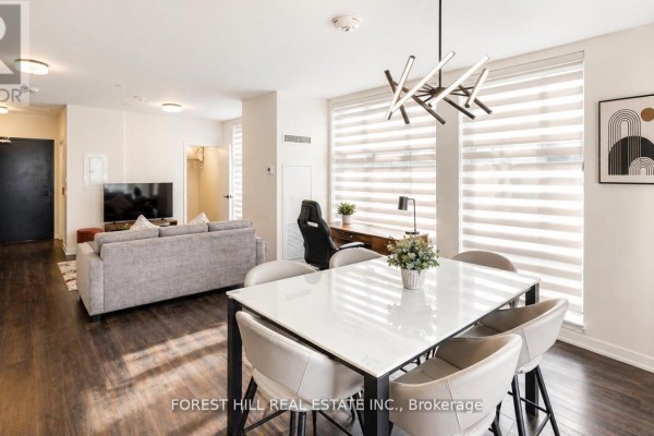 View of the open-concept dining and living area with a desk and chairs. - 104 - 16 Symes Road, Toronto