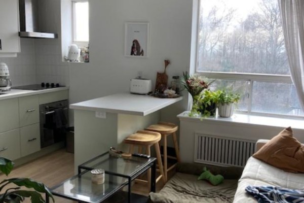 Kitchenette with light green cabinets, white island, and sofa. - 104 - 204 Kingston Road, Toronto