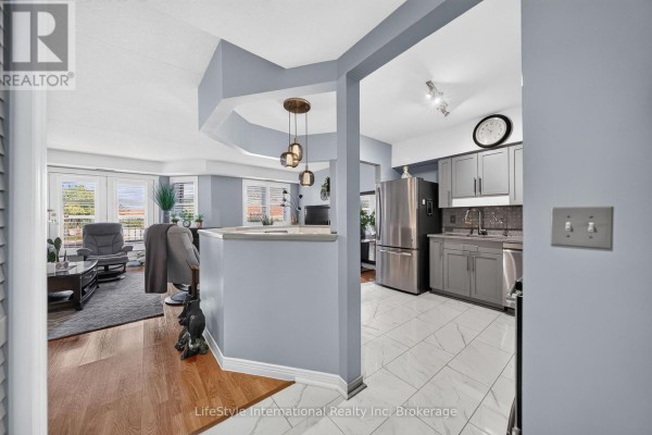 View from living room into kitchen and dining area with patio doors. - 104 - 208 Silvercreek Parkway N, Guelph