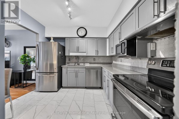 Light grey kitchen with stainless steel appliances, marble tile floor, and modern cabinets. - 104 - 208 Silvercreek Parkway N, Guelph
