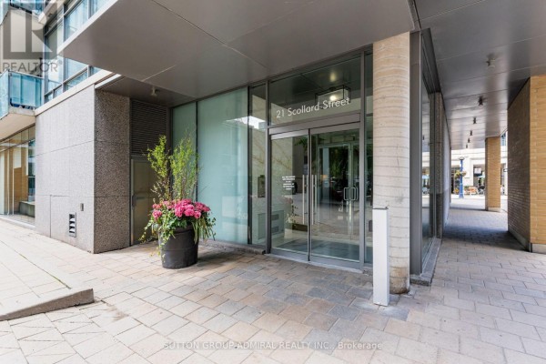 Glass entrance doors to 21 Scollard Street building, with paved walkway and planter. - 104 - 21 Scollard Street, Toronto