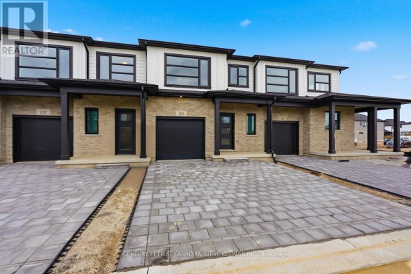 Close-up of the front entrance of a townhouse with a black door and window. - 104 - 2840 Buroak Drive, London North