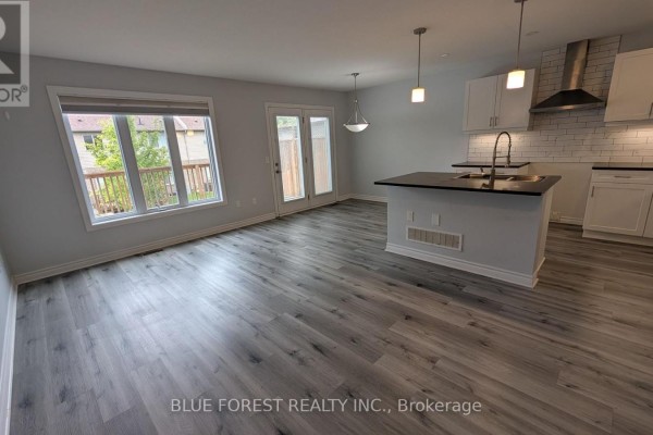 Dining area with light wood table, grey chairs, white rug, and island kitchen. - 104 - 3400 Castle Rock Place, London South