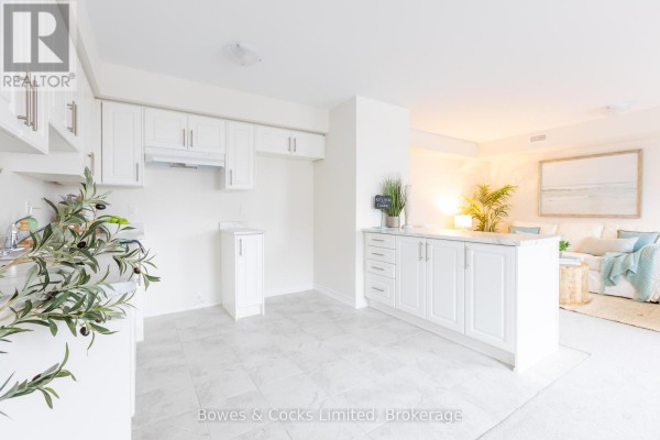 Bright white kitchen with light grey tile floor, white cabinets, and a countertop with marble pattern. - 104 - 48 Maple Avenue, Asphodel Norwood