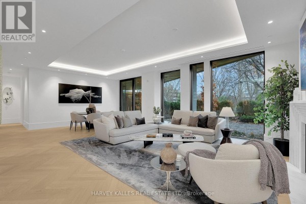 Spacious living and dining area with sectional sofa, fireplace, and large windows to backyard. - 104 - 7 Dale Avenue, Toronto