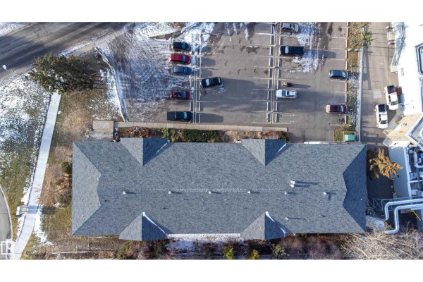 Aerial top-down view of the grey asphalt shingled roof of an apartment building. - #201 104 10 St, Cold Lake