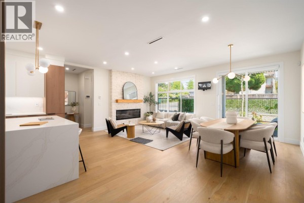 Spacious living and dining area with light wood floors, fireplace, and large sliding glass doors to the outside. - 104 901 Edgar Avenue, Coquitlam
