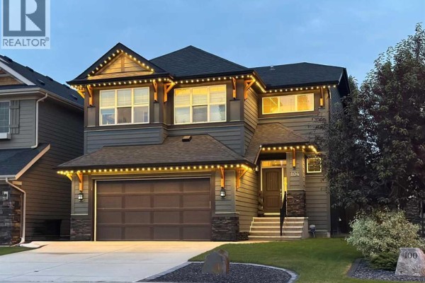 Same house at dusk, decorated with exterior string lights. - 104 Auburn Shores Way Se, Calgary