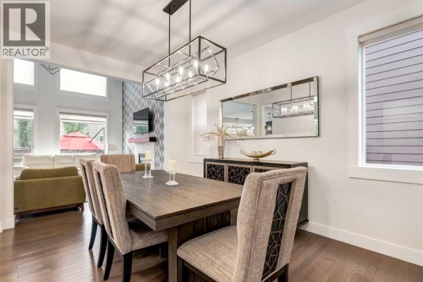 Formal dining room with a dark wood table, upholstered chairs, and sideboard. - 104 Auburn Shores Way Se, Calgary