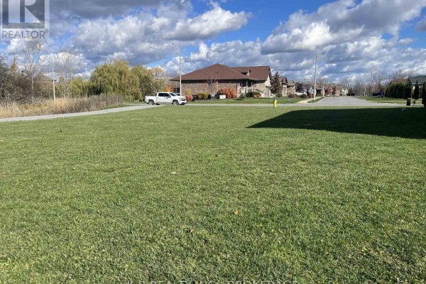 Open grassy area with a view of nearby homes and a fire hydrant, under a blue sky. - 104 Cherrywood Parkway, Greater Napanee