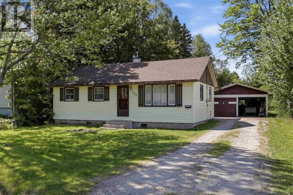 White kitchen with stainless steel appliances and light wood laminate flooring. - 104 Eastern Ave, Sault Ste  Marie
