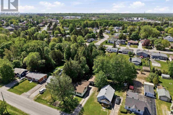 Laundry room with stacked washer and dryer and large window overlooking the yard. - 104 Eastern Ave, Sault Ste  Marie