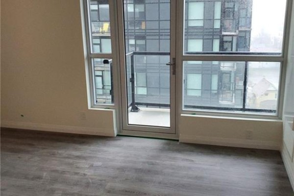 Living area with glass door leading to balcony and large windows with city view. - 104 Garment Street Unit# 803, Kitchener