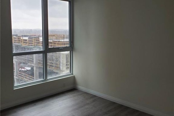 Room with large window showing city construction and distant trees. - 104 Garment Street Unit# 803, Kitchener