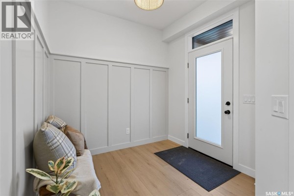 Interior entryway with a bench, decorative pillows, and a frosted glass front door. - 104 Lakewood Drive, Humboldt