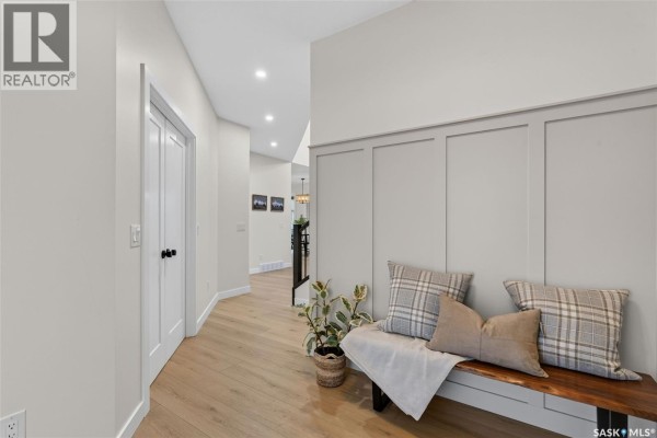 Hallway with light wood floors, a bench, and a view of a staircase. - 104 Lakewood Drive, Humboldt