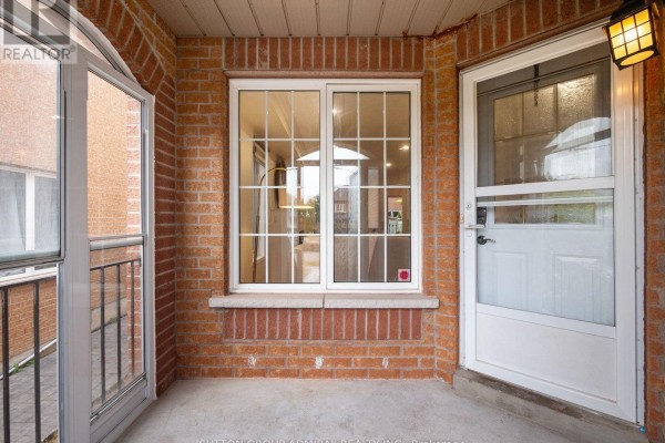 Covered entryway with brick walls, a sliding window, and a white front door. - 104 Parktree Drive, Vaughan
