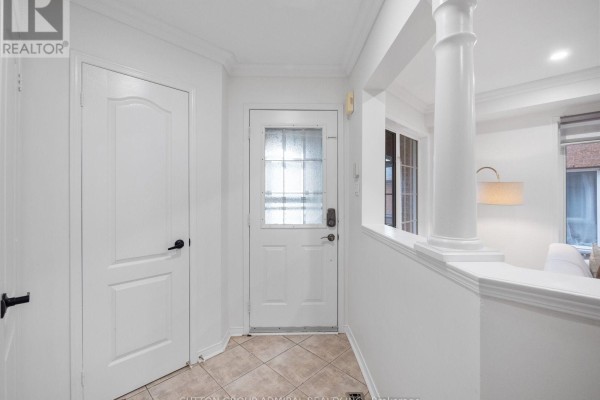 Interior entrance foyer with beige tile floor, white doors, and decorative columns. - 104 Parktree Drive, Vaughan