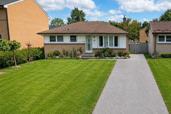Exterior view of a one-story brick and white siding house with a paved driveway and green lawn. - 104 Queenston Crescent, London East