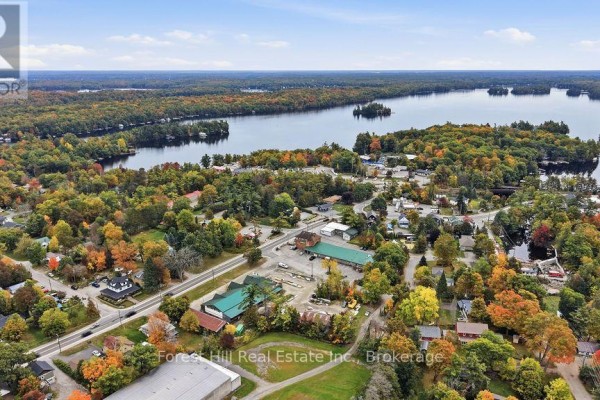Aerial view of a town with a lake and surrounding forest in the fall. - 1040 River Street, Muskoka Lakes