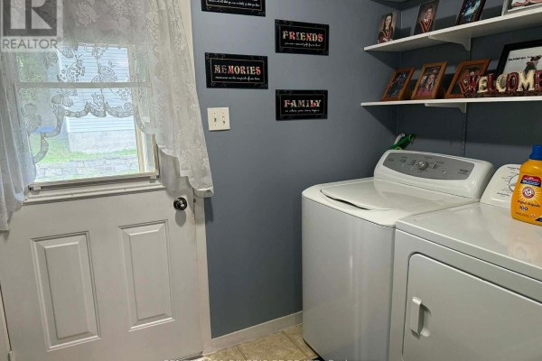 Laundry room with a white washing machine, dryer, and a door with a window. - 10407 Hainsville Road, South Dundas