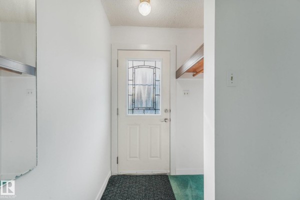 Interior view of a small entryway with white walls and a glass-paneled door. - 10410 Lauder Av Nw, Edmonton
