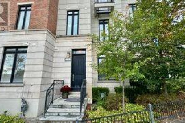 Front entrance of a townhouse with a dark door, stone steps, and metal railings. - 1042 Avenue Road, Toronto