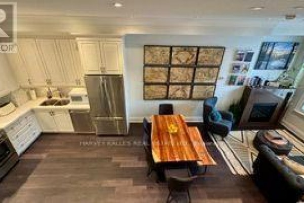 Open concept living area with a kitchen, dining table, and fireplace. - 1042 Avenue Road, Toronto