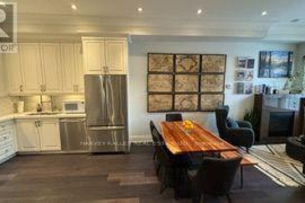 Kitchen area with white cabinets, stainless steel appliances, and a dining area. - 1042 Avenue Road, Toronto